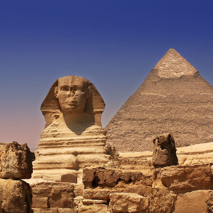 the Sphinx and the Pyramids of Giza in Egypt, with the ancient structures set against a clear, bright sky