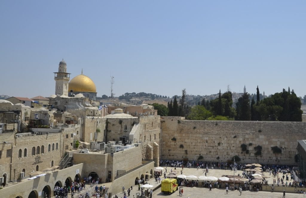 the Western Wall and Temple Mount in Jerusalem, with the Dome of the Rock visible in the background under a clear sky