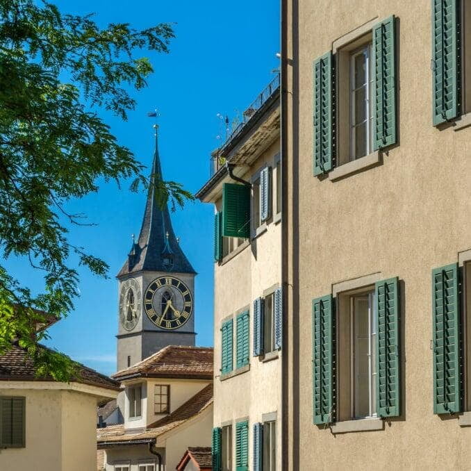 St. Peter Protestant Church in Zurich, Switzerland, with its iconic clock tower under a clear blue sky