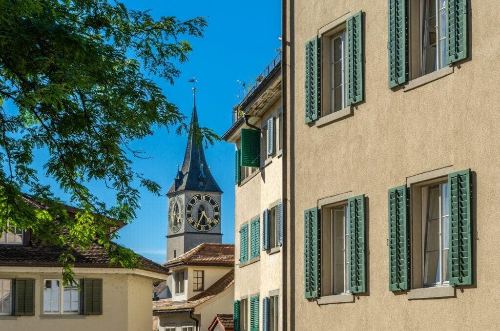 St. Peter Protestant Church in Zurich, Switzerland, with its iconic clock tower under a clear blue sky