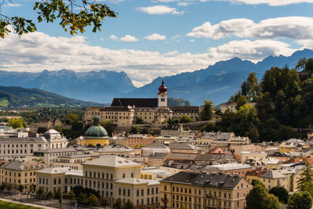 Salzburg, Austria, with its historic buildings and scenic landscape set against a backdrop of rolling hills and a clear sky